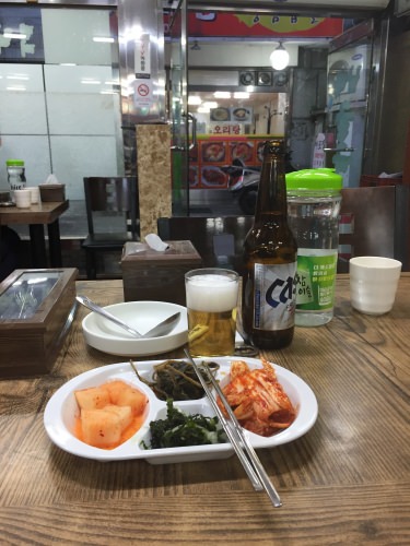 店内から外を見ながらおかずをつまんで