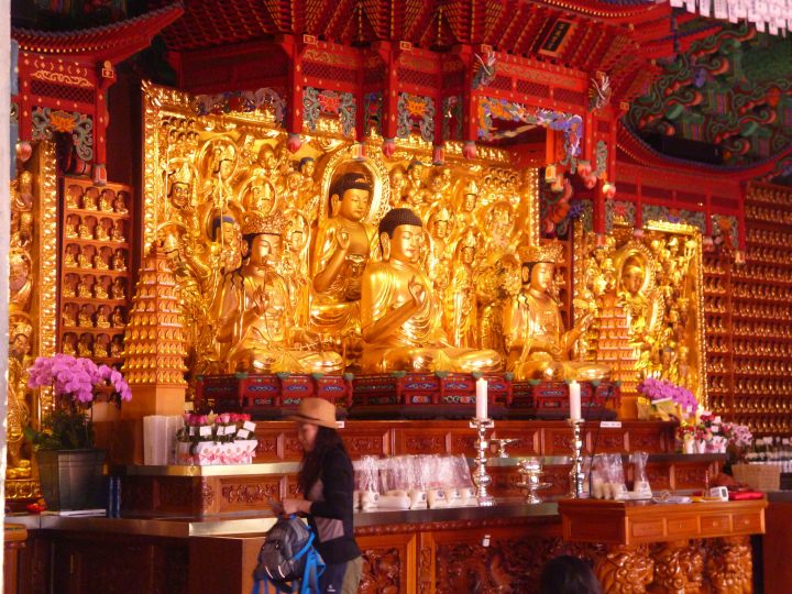 金色の仏像、皆一生懸命に祈りを捧げています