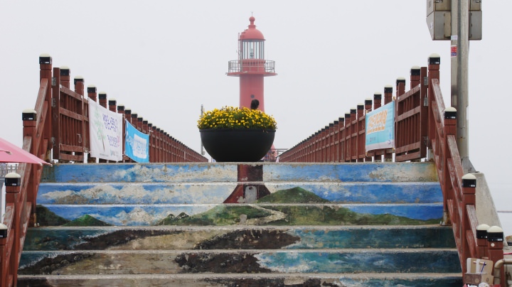 島の北西にある赤い「済扶島灯台」。灯台へ向かう階段には、なぜか灯台の絵が描かれています。灯台の下にはモーターボート乗り場がありました。