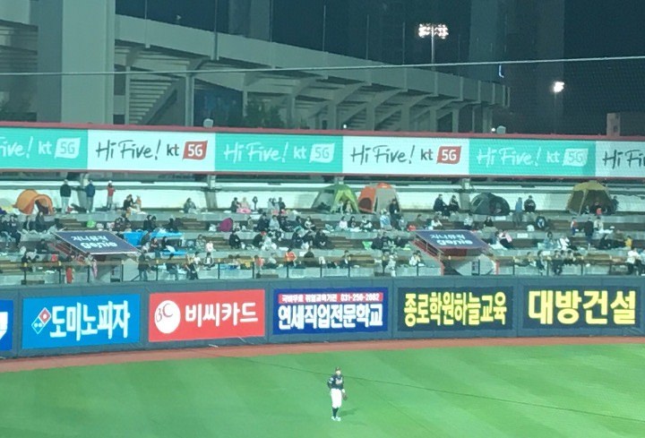 おそらく持参と思われるテントが並ぶのどかな外野席