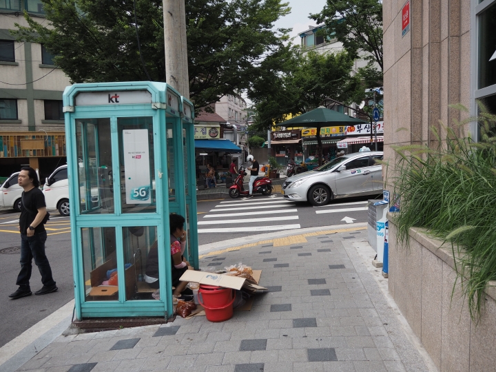 公衆電話の中でキムチを売るおばさん