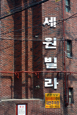 ファミマの角にあるこの「ビラ」を見つければOK!この角を左へ入って1分です。