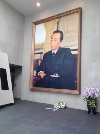 入口の巨大肖像画の下には献花が置かれていました