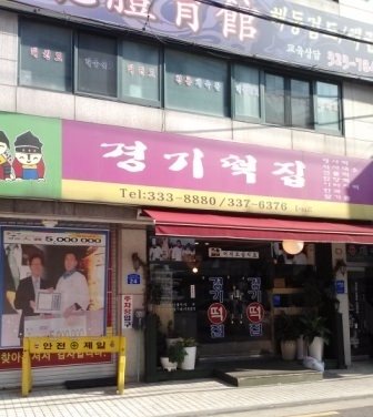 古めかしい店に、なぜか洋装の職人くんの写真